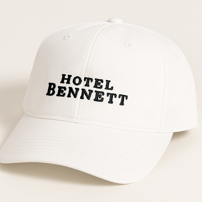 White cap with 'HOTEL BENNETT' text on a light beige background